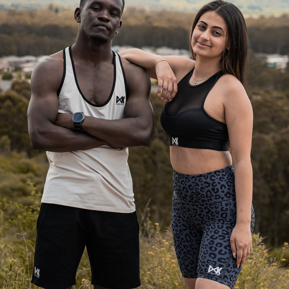 IXK Gear Gym Shorts in Colour: Dark Grey paired with IXK Gear Mesh Sports Bra in Colour: Black. Male model is weaing the IXK Gear Stringer in Stone and Cotton Stretch Shorts in Black