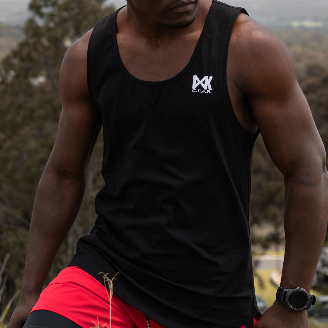 IXK Gear Muscle Tank Top in Black paired with Quick Dry Accent Shorts in Red. Natural background.